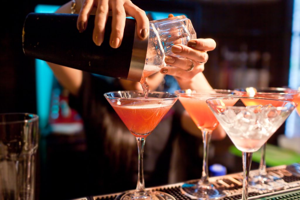 The girl bartender prepares a cocktail in the nightclub.